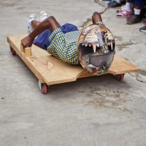 Kumasi Ghana student rides a wooden skeleton